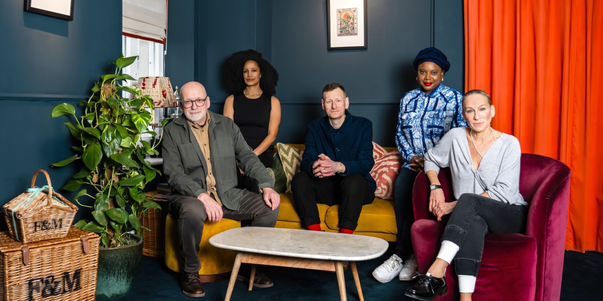 The Booker Prize 2025 judges - Ayọ̀bámi Adébáyọ̀, Chris Power, Roddy Doyle, Sarah Jessica Parker and Kiley Reid - sitting together on a yellow velvet sofa and burgundy velvet armchair