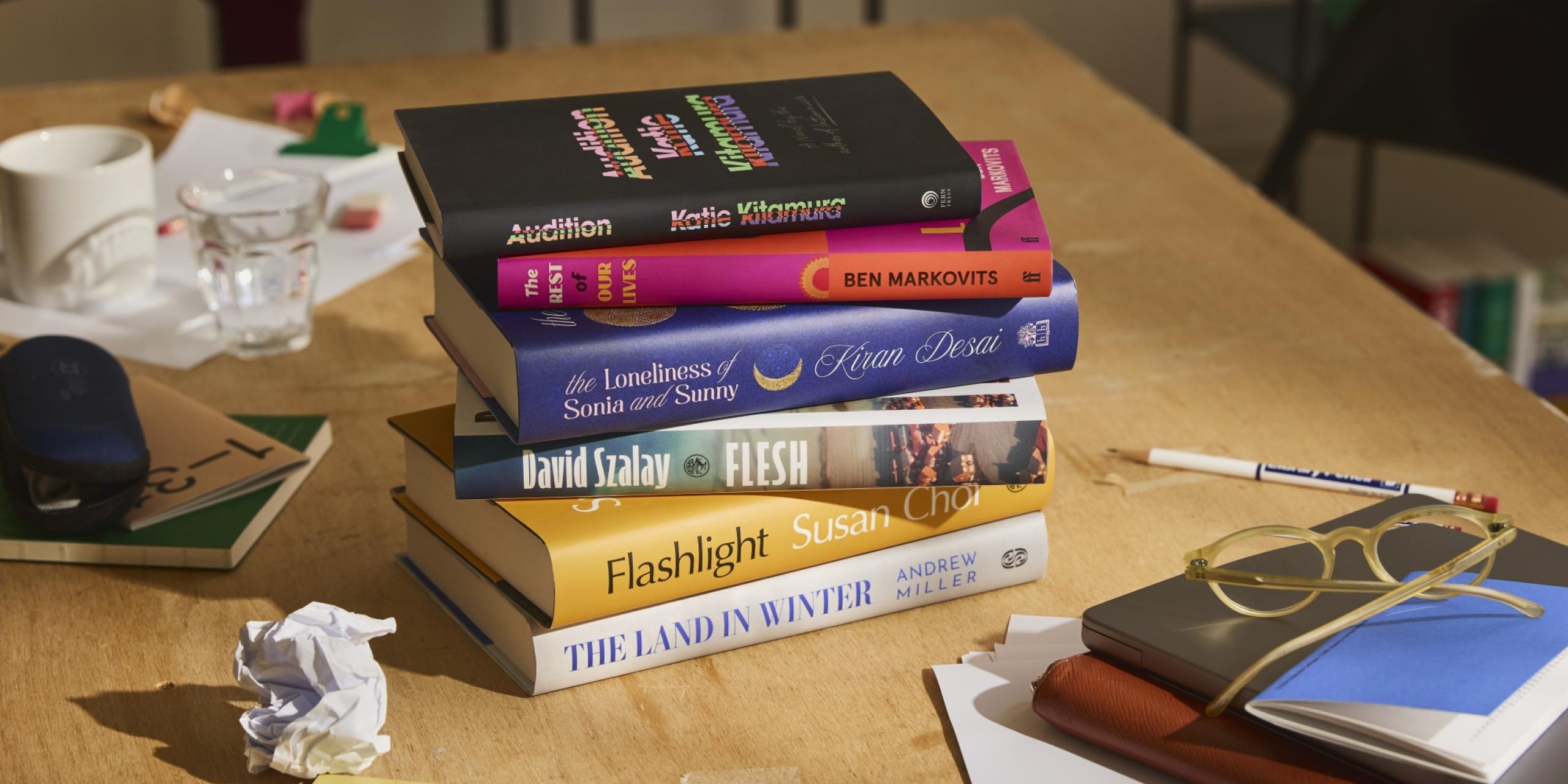 The Booker Prize 2025 shortlist of six books, displayed artfully on a desk