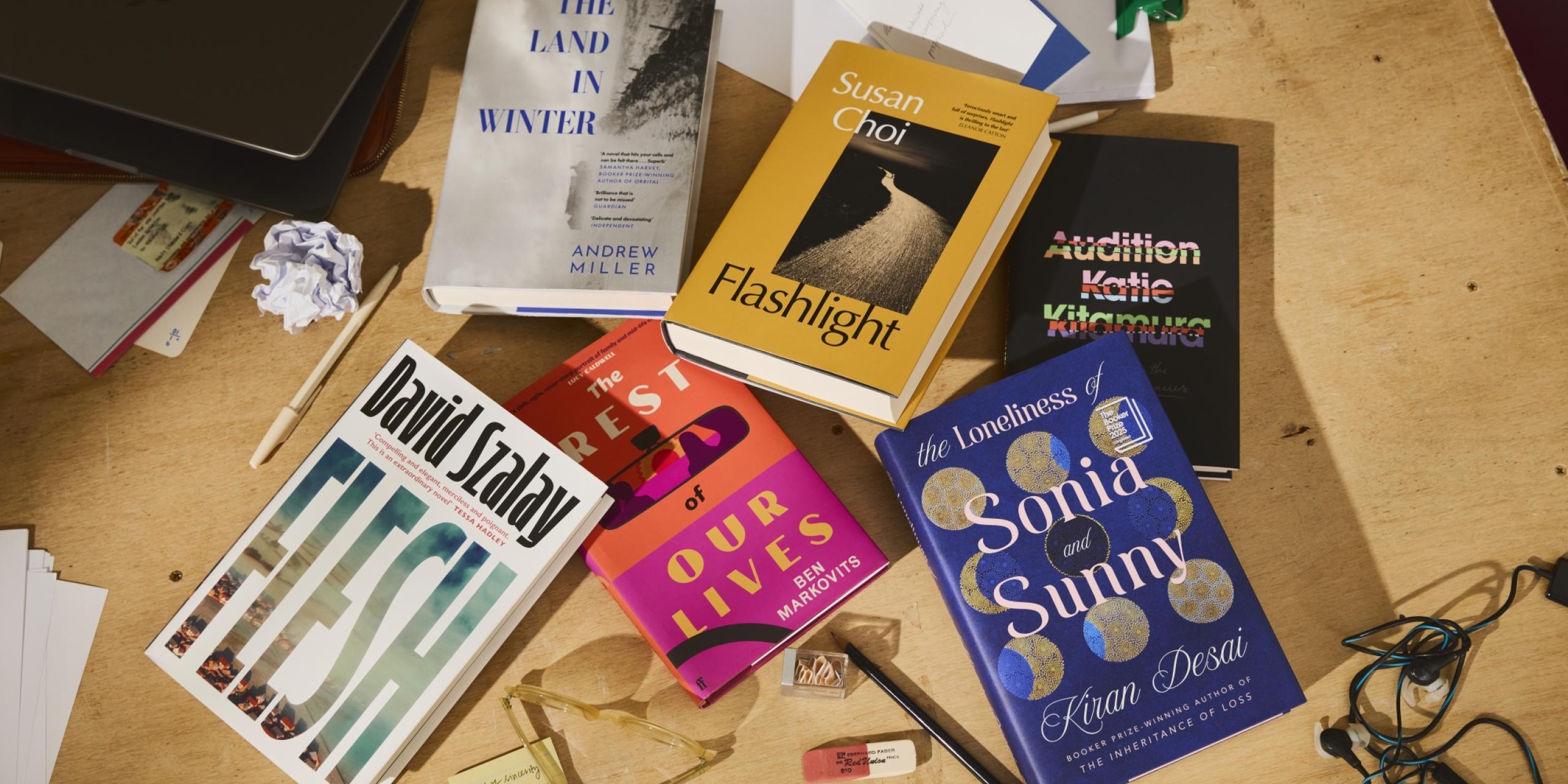 The Booker Prize 2025 shortlist of six books, displayed artfully on a desk