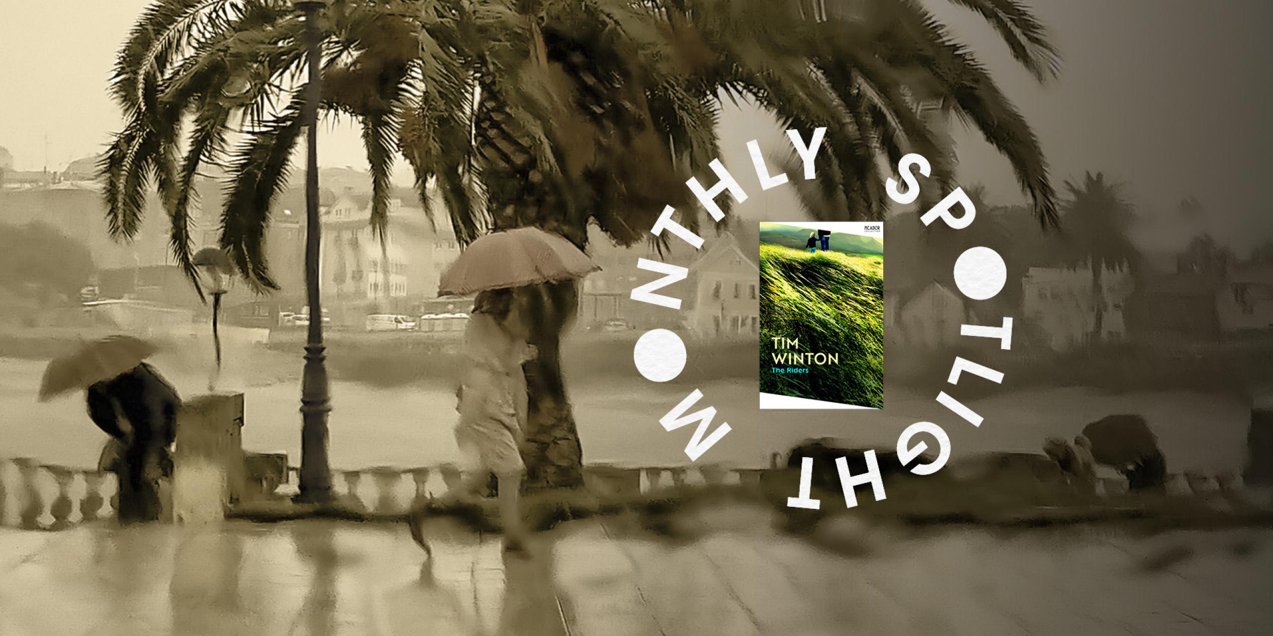 A person holding an umbrella walking across a path with a river in the background