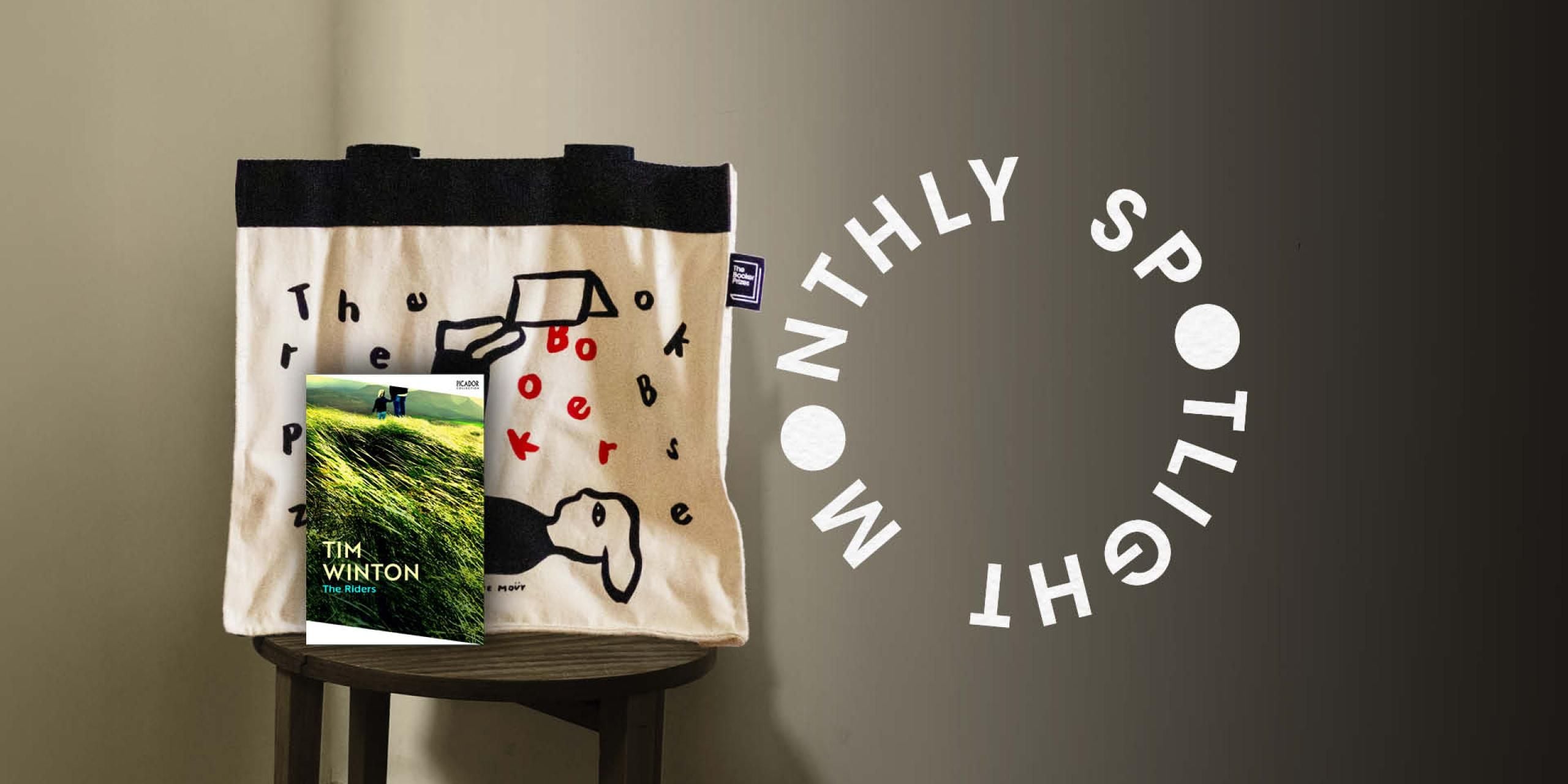 The Riders book resting against a Booker Prize tote bag with the words Monthly Spotlight in a circle